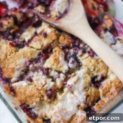 Freshly baked blackberry cobbler, golden and bubbling, with a side of cream ready to serve.