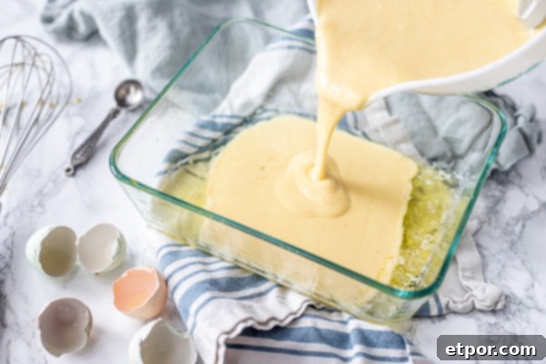 pouring pancake batter into a baking dish with butter