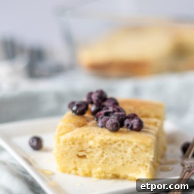 sourdough baked pancake topped with blueberries on a white plate