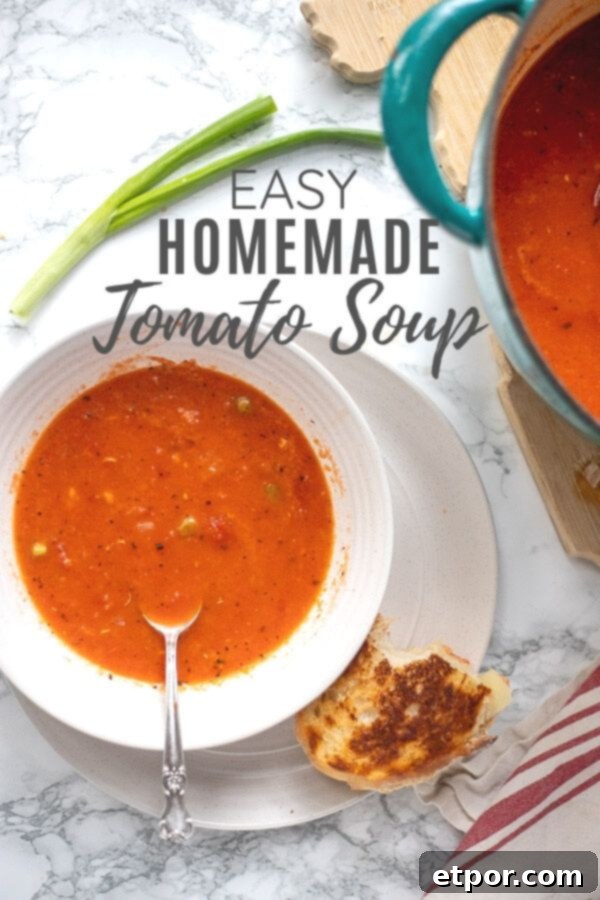 tomato soup in a bowl with sourdough grilled cheese to the right. Turquoise dutch oven with more soup to the right.