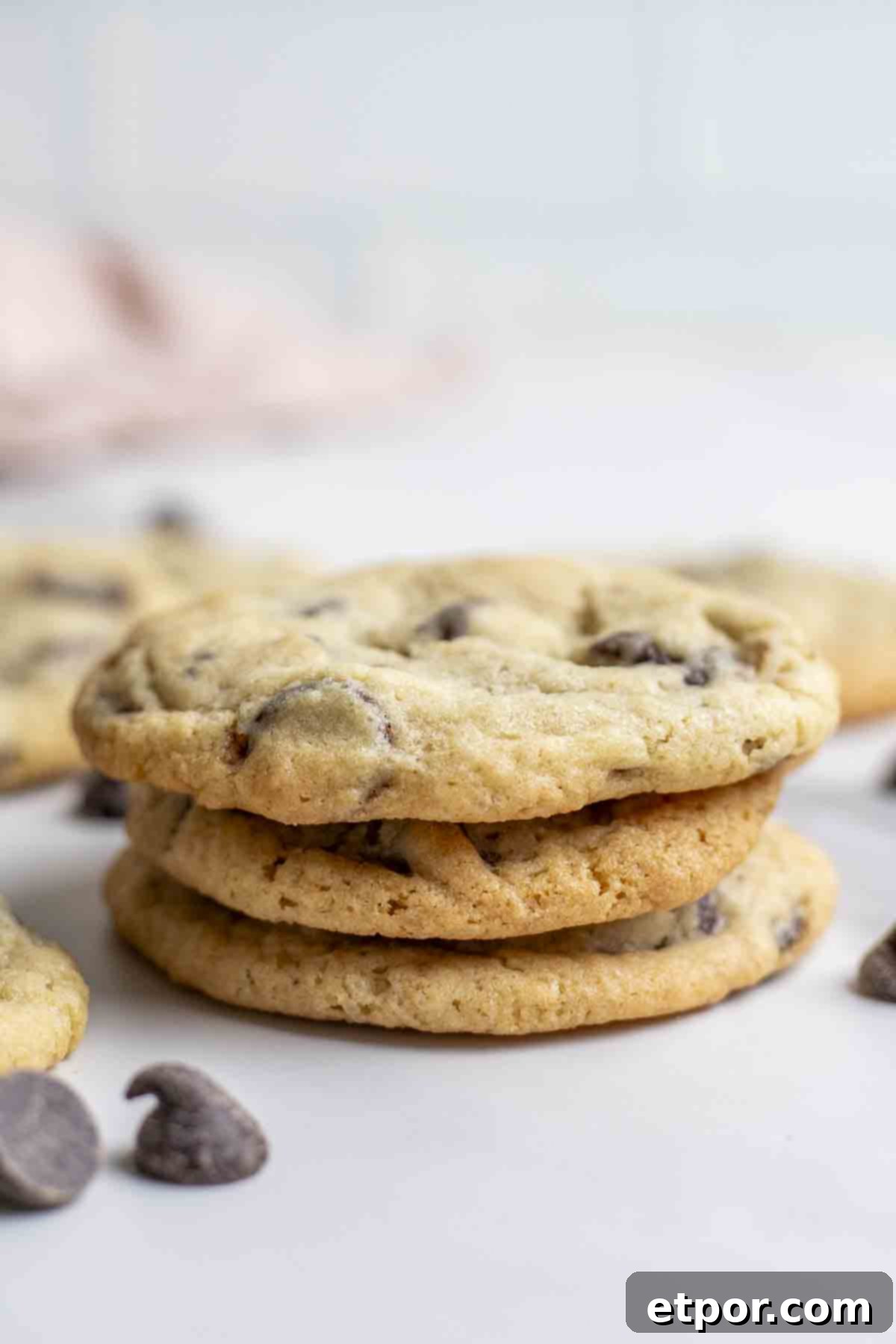 Cultured Chocolate Chip Cookies 4 Three perfectly baked sourdough chocolate chip cookies stacked on top of each other, showcasing their appealing chewiness and golden-brown finish.