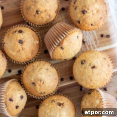overhead shot of sourdough chocolate chip muffins on a wood cutting board.