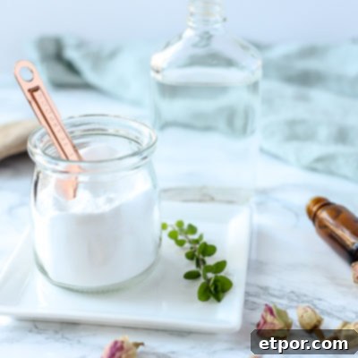 natural homemade toilet cleaner in a glass dish on a white plate with herbs