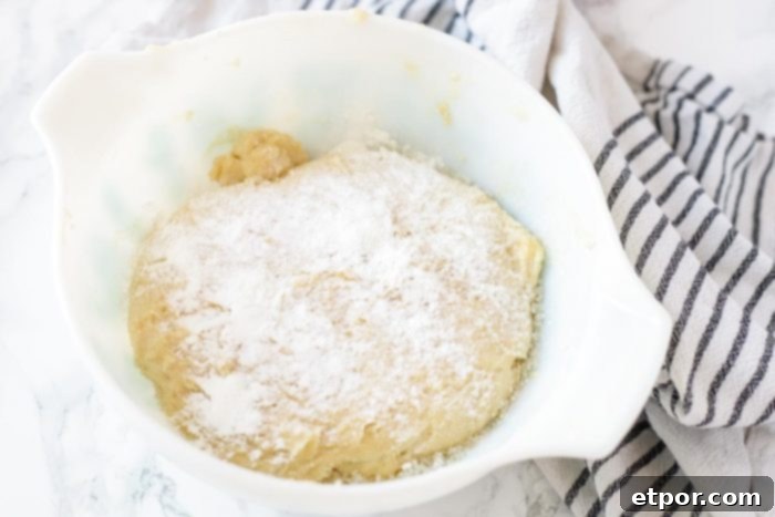 sourdough biscuit dough with baking soda, salt, and baking powder sprinkled on top evenly