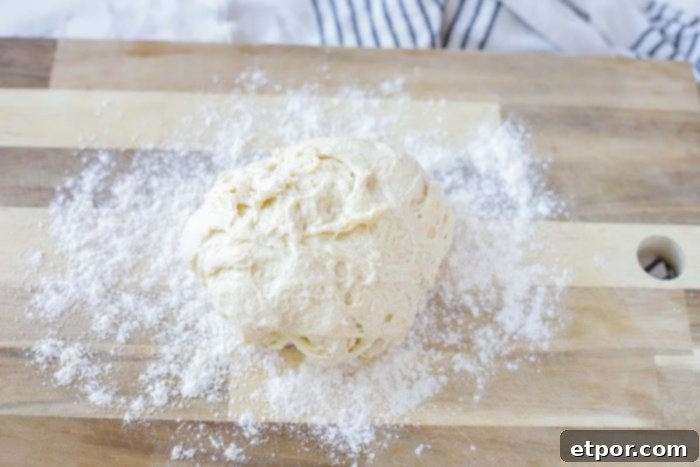 sourdough biscuit dough on a floured wood cutting board
