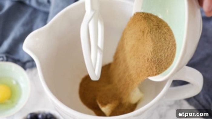 coconut sugar being added to butter in a stand mixer