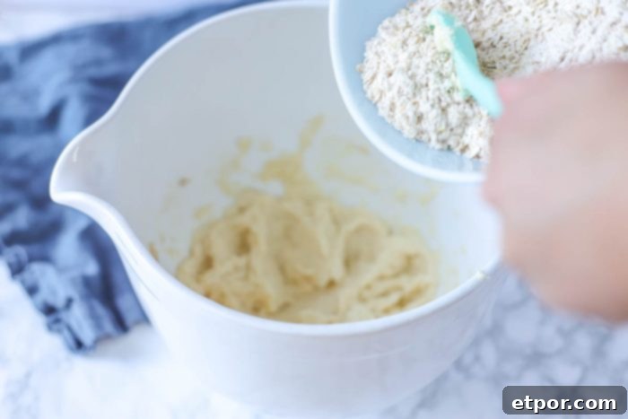 oats being added to whipped butter and sugar