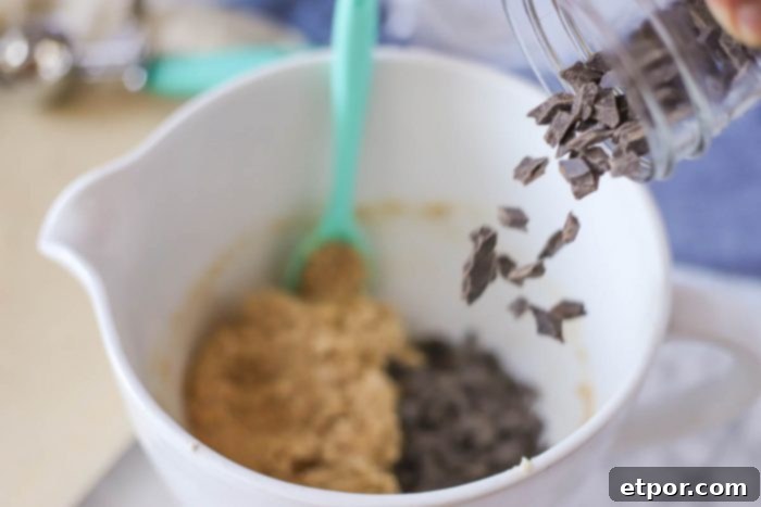 adding chocolate chips to oatmeal cookie dough