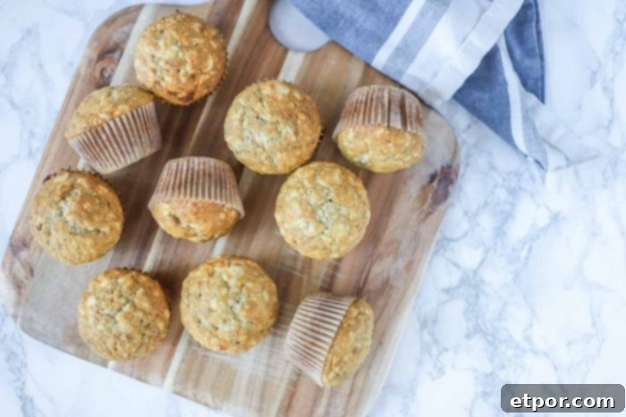 Overhead shot of sourdough banana muffins arranged on a wooden cutting board, emphasizing their golden color and inviting texture.