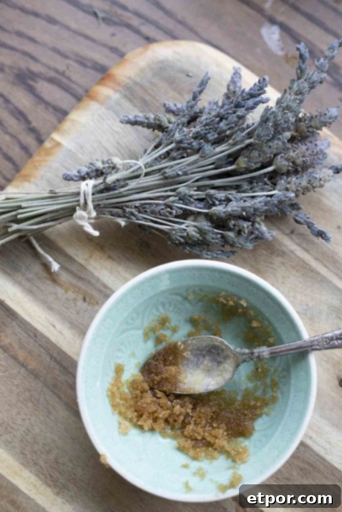Whip Up Your Own Lip Scrub 3 lip scrub in a teal bowl on a wood cutting board with a bundle of lavender