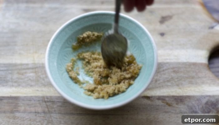 Whip Up Your Own Lip Scrub 9 mixing diy lip scrub in a teal bowl on a wood cutting board
