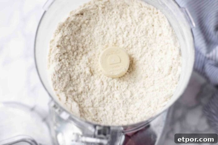 Effortless Sourdough Blueberry Scones 4 Cold butter and flour being processed in a food processor, creating a crumbly mixture.