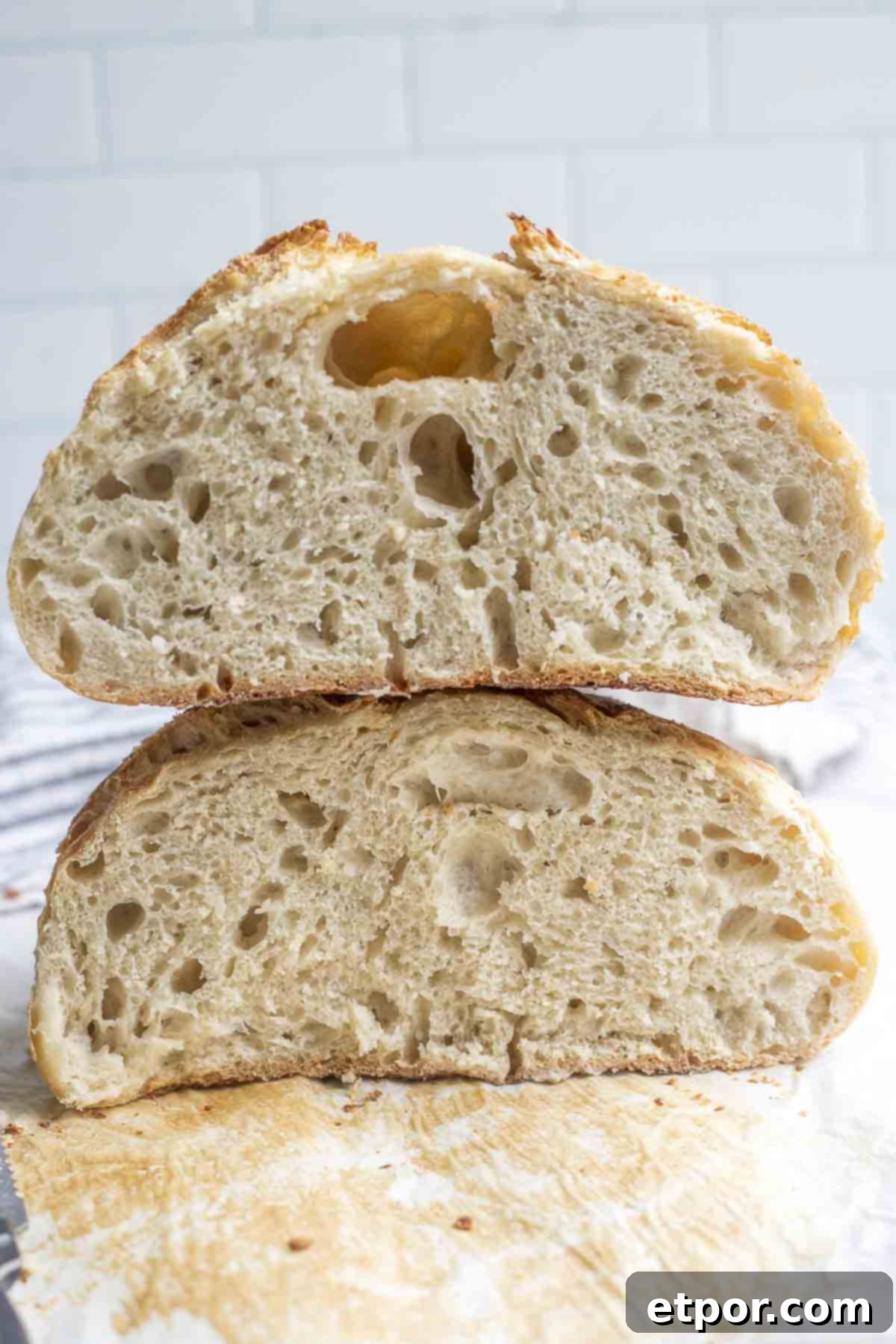 A loaf of easy sourdough bread sliced in half and stacked on top of each other.