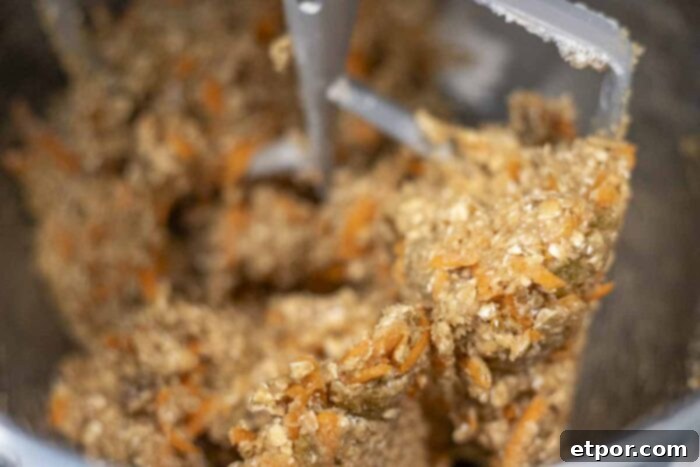 Sourdough carrot cake cookie dough in a stand mixer with paddle attachment.