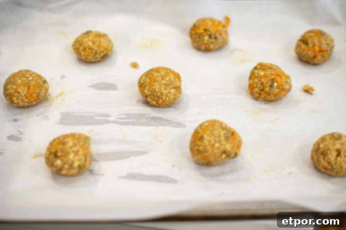 cookie dough balls on a parchment lined baking sheet.