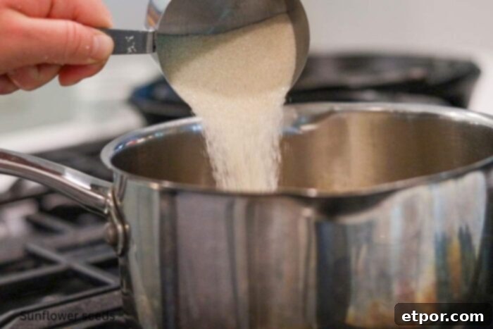 sugar being added to a pot of water on a stove.