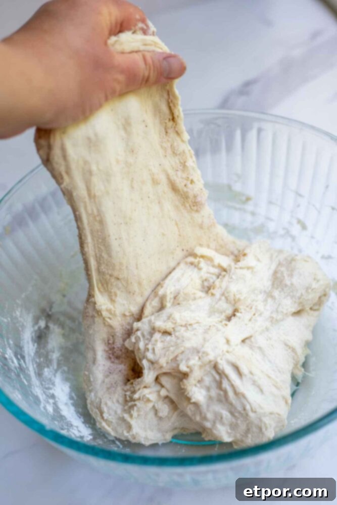 Pulling dough up to perform a stretch and fold.