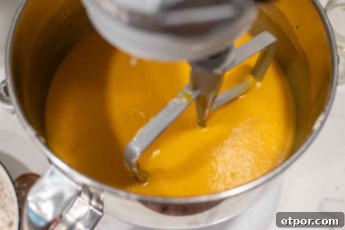 Pumpkin puree, eggs, starter and a few other ingredients in a stand mixer bowl.