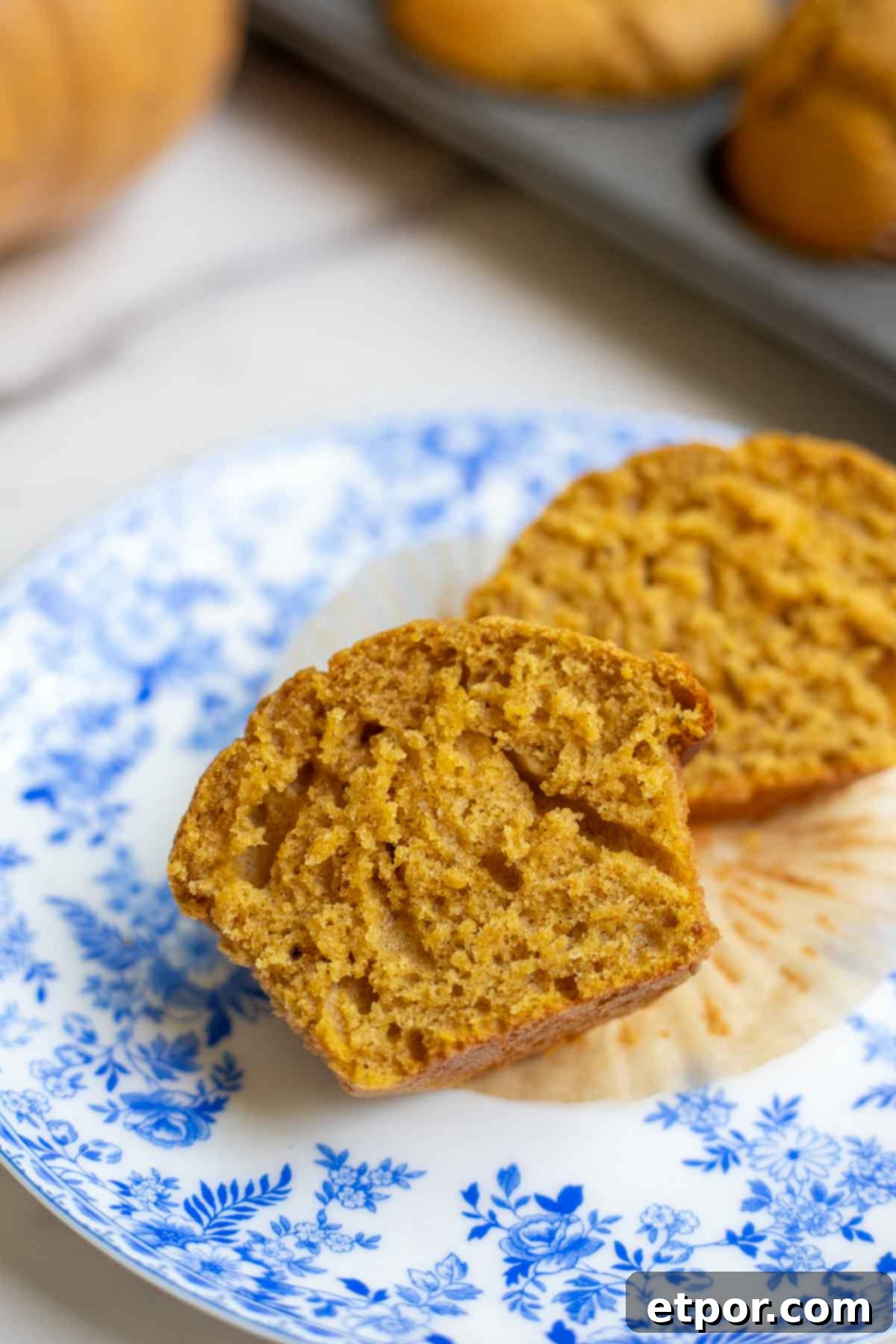 Sourdough pumpkin muffin cut in half revealing a super soft and fluffy interior. 