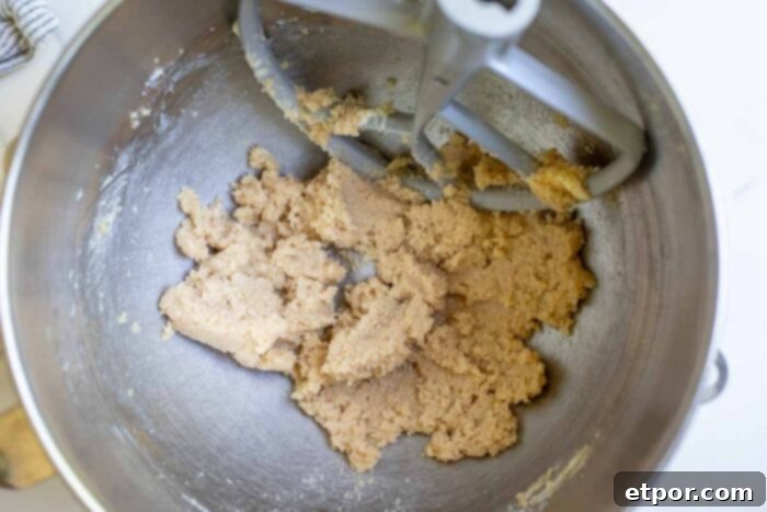 Butter and sugar being creamed together in a stand mixer until light and fluffy.