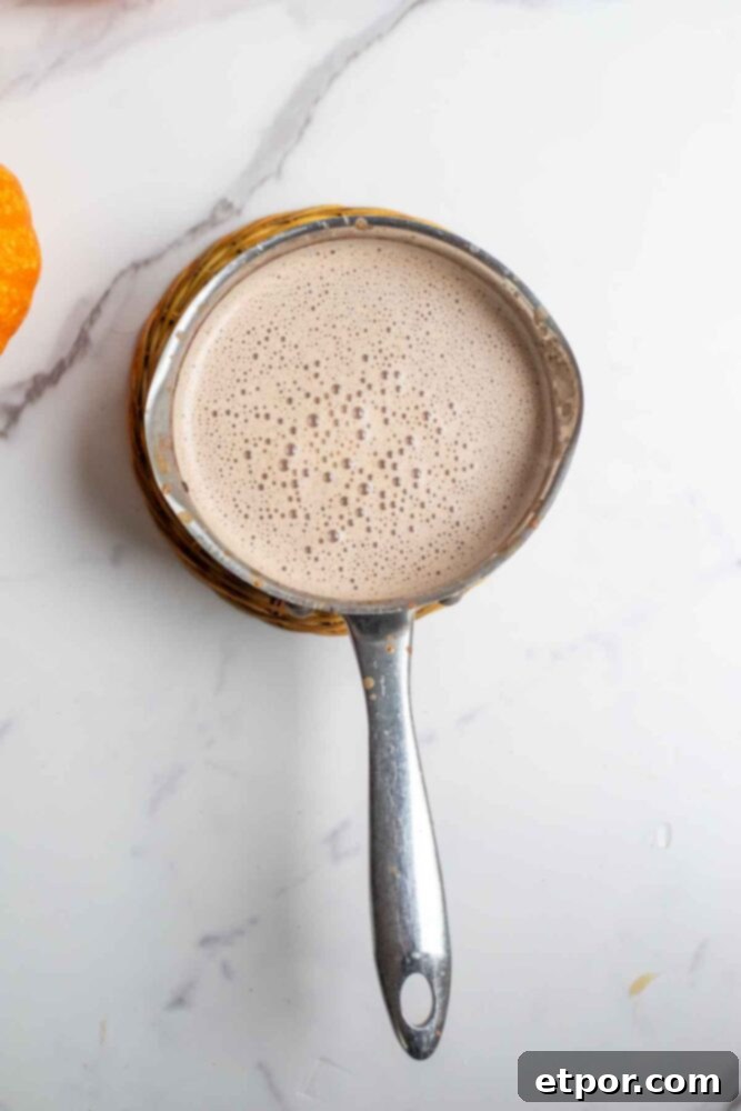 Pumpkin spice hot chocolate heated in a saucepan.