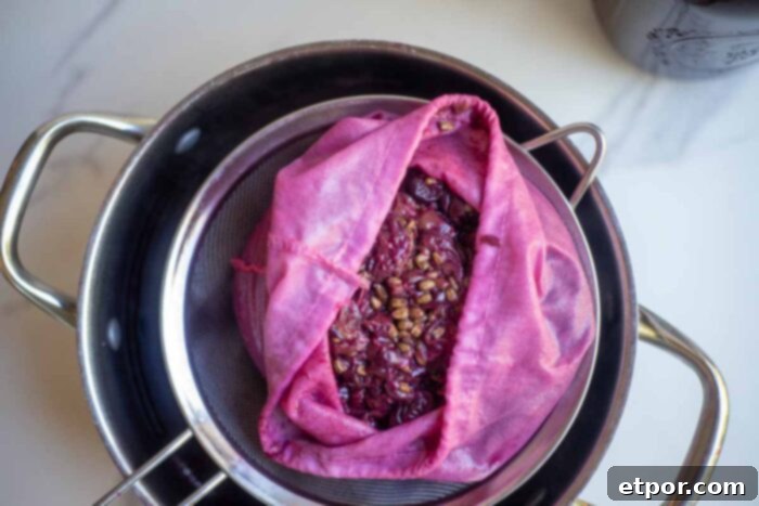 Strained grape juice through a jelly bag and strainer over a pot.