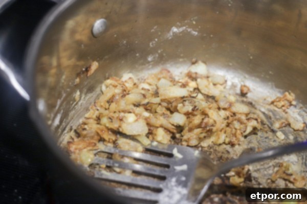 onions sautéing in a pot with flour