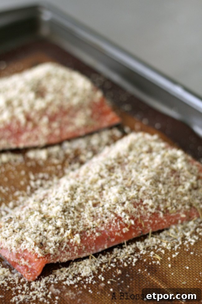 raw salmon with almond flour crust on a baking sheet, ready for the oven