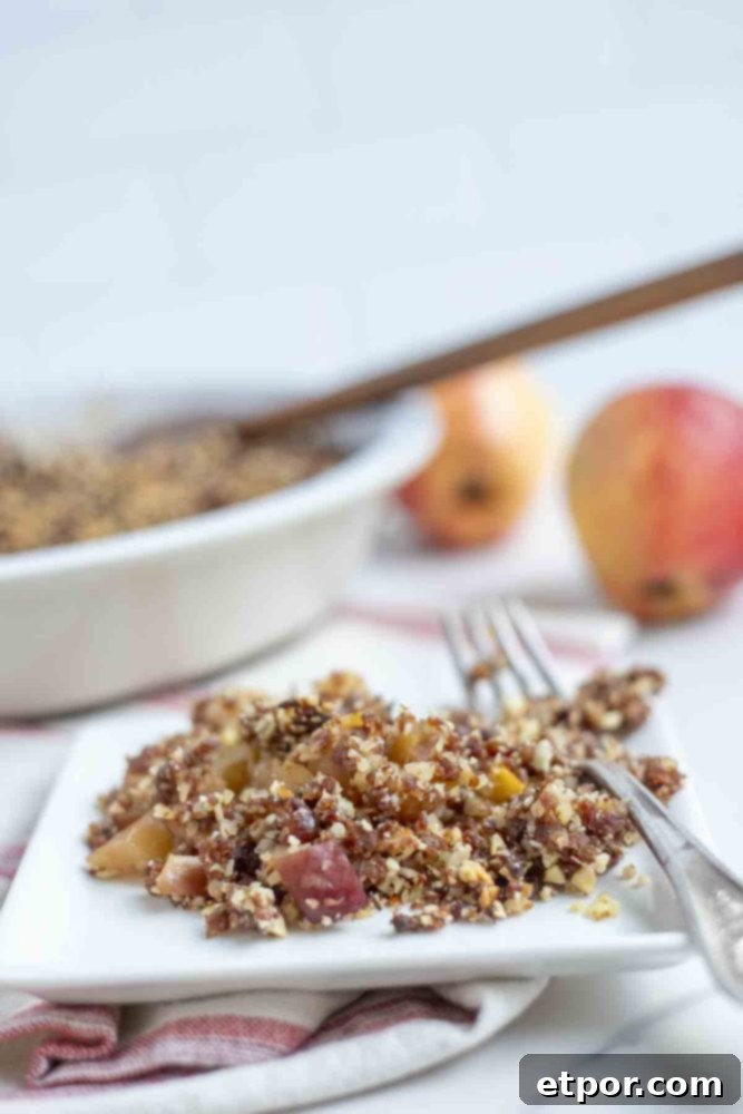 gluten free apple crisp on a white plate with a vintage fork on a red and cream stripped towel