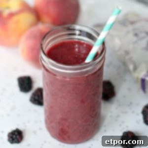 Delicious and healthy berry peach kombucha smoothie presented in a glass, ready to be enjoyed.