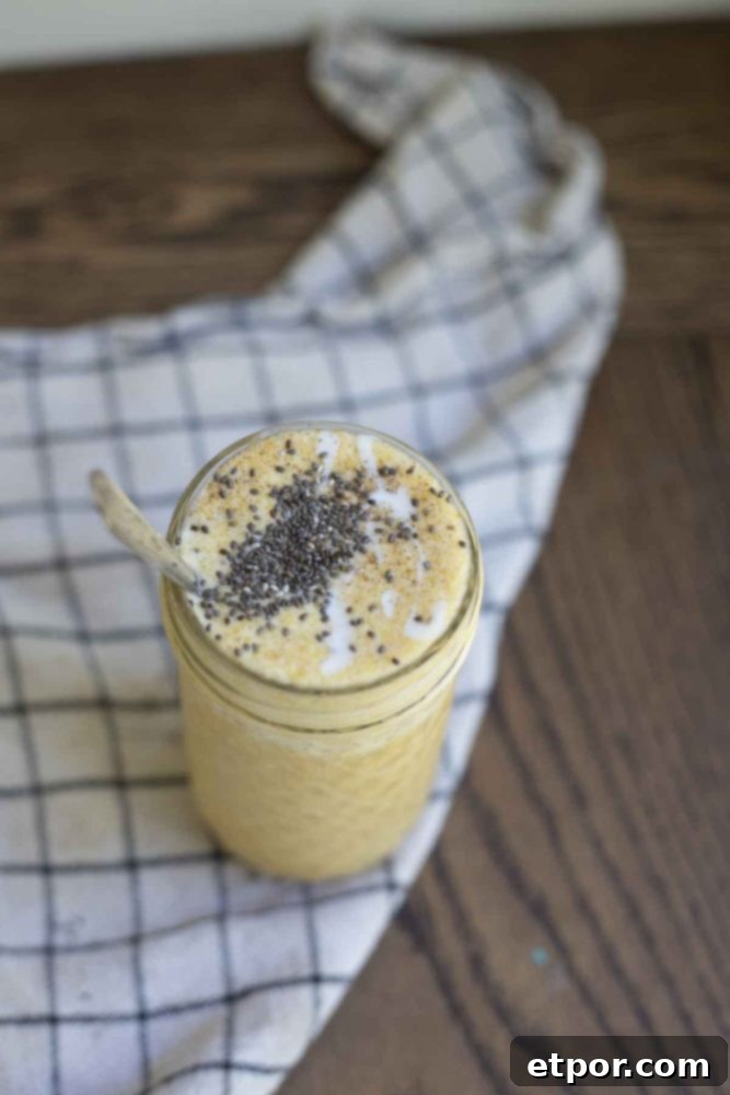 Spiced Pumpkin Pie Bliss Smoothie 4 photo of pumpkin spice smoothie topped with chia seeds and yogurt in a glass jar on a black and white checked towel