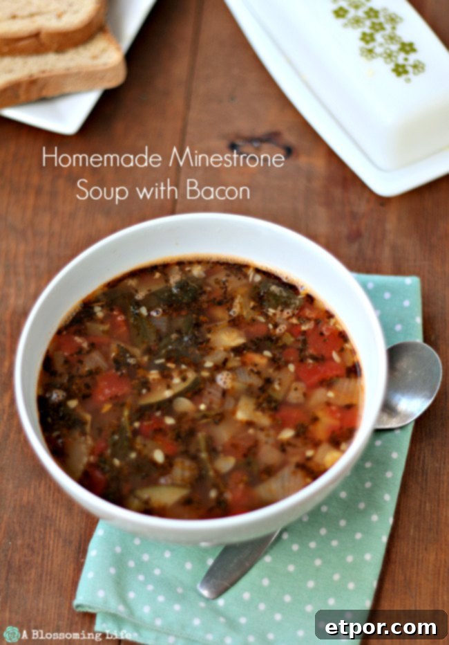 Smoky Bacon Minestrone Comfort Food 11 A comforting bowl of minestrone soup sits beside a polka dot napkin and a spoon, inviting a warm meal.