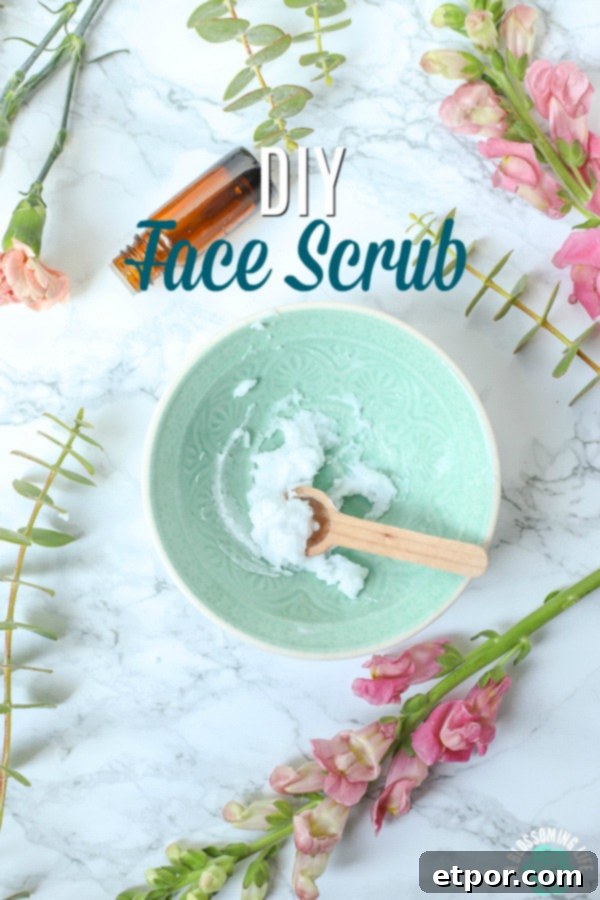 teal bowl of DIY face scrub with a wooden spoon and flowers all around.