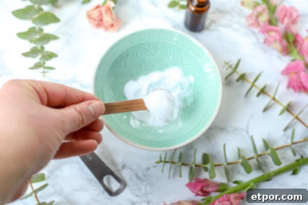 wooden spoon with coconut oil to make DIY Face Scrub in teal bowl