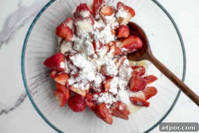 Simple Strawberry Crumble Bliss 7 strawberries sprinkled with cornstarch, sugar, and vanilla in a glass bowl.