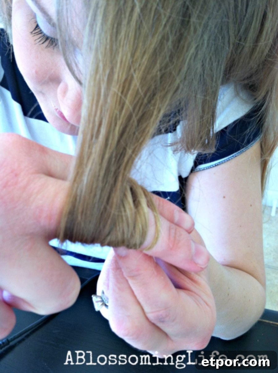 women looping hair around her fingers for flat iron curls