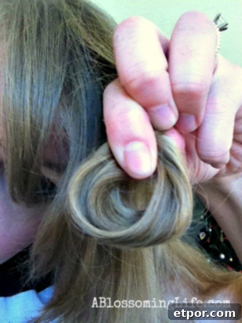 women holding a loop of hair - how to flat iron curl your hair