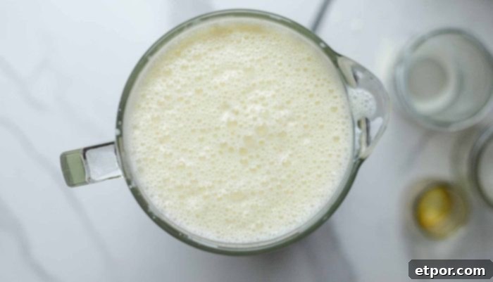 egg cream mixture blended in a blender with jars to the right