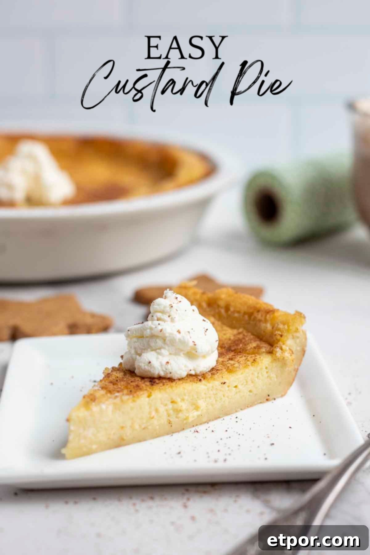 slice of custard pie topped with whipped cream on a white plate with a pie plate with more pie in the background.