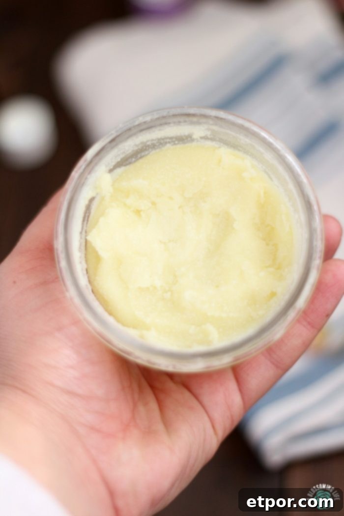 hand holding a jar of homemade healing salve