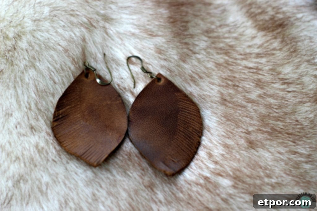 pair of brown DIY leather earrings laying on faux fur
