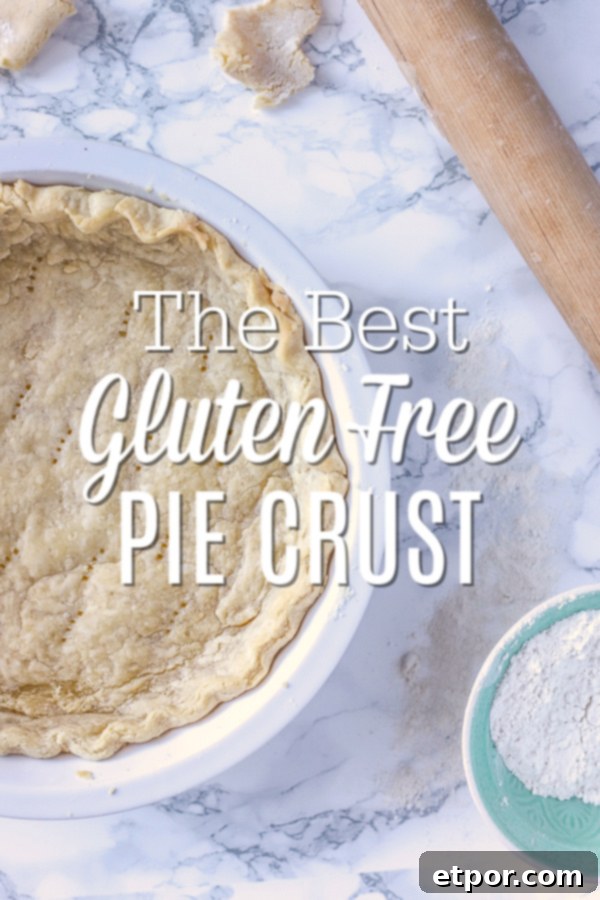 Gluten Free Pie Crust in a pie pan laying on a marble counter with a rolling pin and bowl of gluten free flour