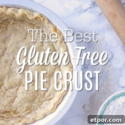 Gluten Free Pie Crust in a pie pan laying on a marble counter with a rolling pin and bowl of gluten free flour