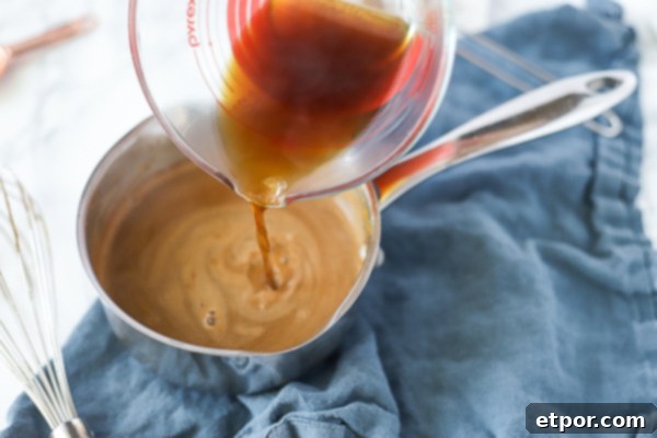 pouring pumpkin spice latte into a mug