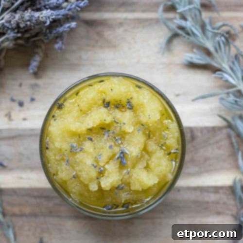 overhead photo of a sugar scrub on a wood cutting board and dried lavender frames the jar