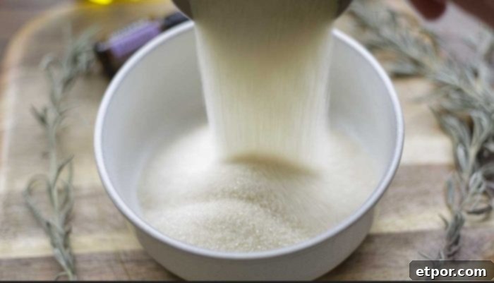 Homemade Lavender Bliss Body Polish 8 Adding sugar to a bowl on a wood cutting board surrounded by lavender sprigs