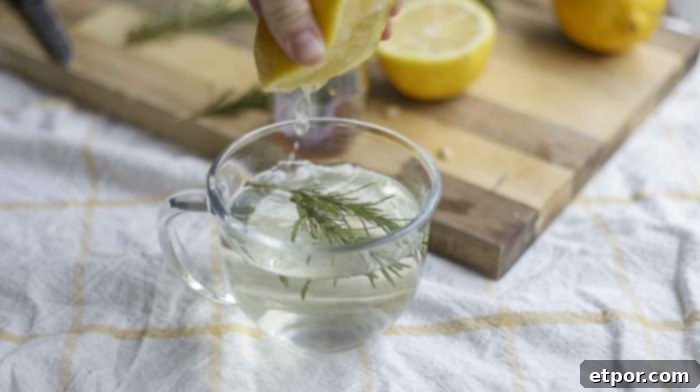 hand squeezing lemon into a mug