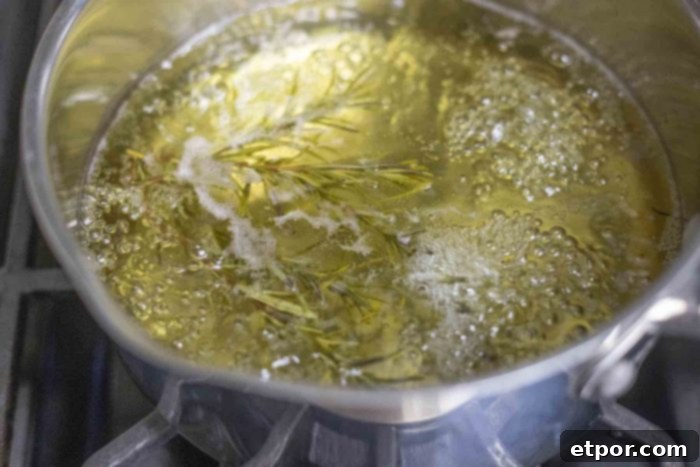 rosemary and water simmering in a small saucepan