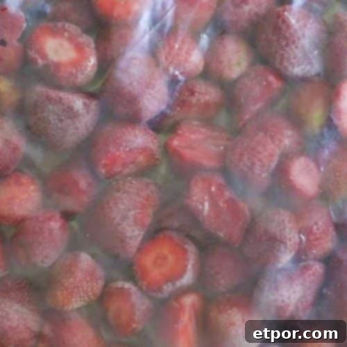 A freezer-safe plastic bag filled with individually frozen strawberries, showcasing successful preservation.