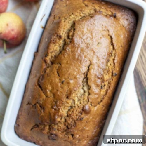 Overhead photo of sourdough cinnamon apple bread on a white and yellow towel with apples on top